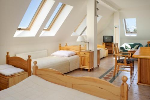a bedroom with two beds and a desk and a table at Pensjonat Mijamar in Białogóra