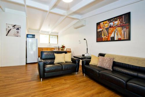 a living room with two leather chairs and a couch at Peppermint Brook Cottages in Margaret River Town