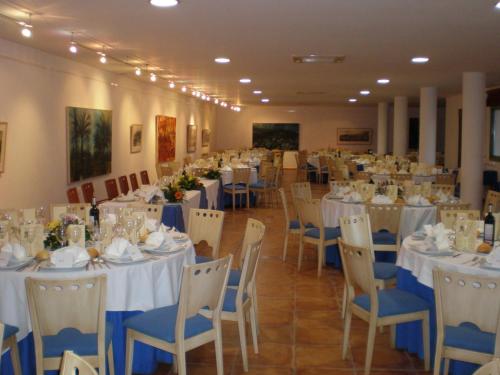 a banquet hall with white tables and blue chairs at Hotel de Naturaleza Rodalquilar & Spa Cabo de Gata in Rodalquilar