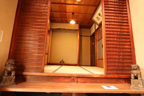 - un miroir dans une chambre avec des escaliers en bois dans l'établissement Satsukian, à Kyoto