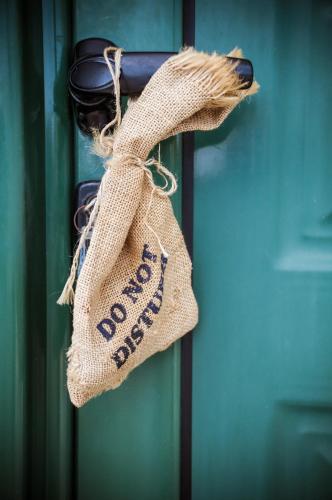a burlap bag with the words do not disturb on a door at Anthi Maria Beach Apartments in Pefki Rhodes