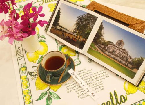a cup of coffee and a picture of a house at Aster 9 House in Bangkok