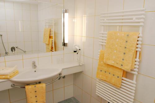 a bathroom with a sink and a mirror and towels at Hotel Florianerhof in Markt Sankt Florian