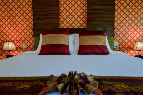 a bedroom with a bed with red and gold pillows at Sita Beach Resort in Ko Lipe