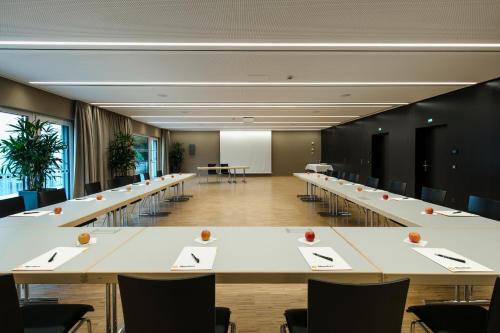 an empty conference room with tables and chairs at Montfort - das Hotel in Feldkirch