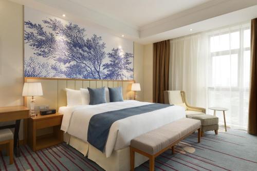 蘇州市にあるRamada Suzhouの大きなベッドと机があるホテルの部屋