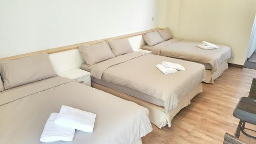Habitación con 3 camas y sábanas blancas. en 海明威民宿 台東縣民宿編號0849號, en Isla Verde