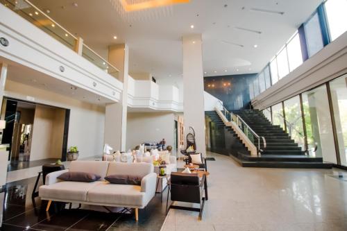 a lobby with couches and chairs in a building at Fortune Hotel Korat- SHA Plus in Nakhon Ratchasima