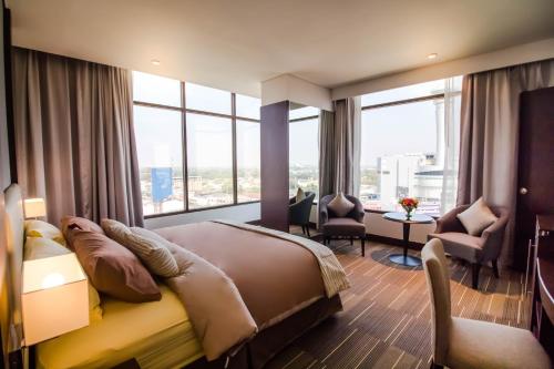 a bedroom with a large bed with a large window at Fortune Hotel Korat- SHA Plus in Nakhon Ratchasima