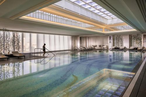a person is standing in a large swimming pool at Four Seasons Hotel Tianjin in Tianjin