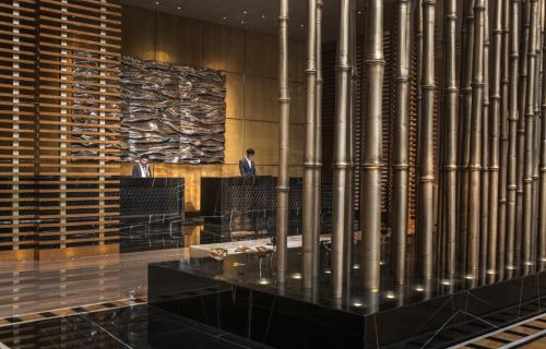 a man standing in the lobby of a building at Four Seasons Hotel Tianjin in Tianjin