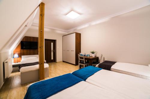 ザモシチにあるNoclegi10Aのベッド2台とデスクが備わるホテルルームです。
