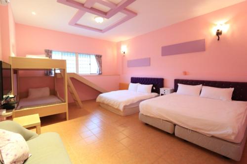 a bedroom with two beds and a bunk bed at 橘子喵旅宿 in Hengchun South Gate