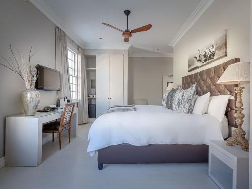 a bedroom with a bed and a desk and a television at Long Street Boutique Hotel in Cape Town