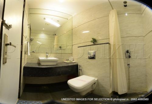 a bathroom with a toilet and a sink and a shower at Palm Galaxy in Itimādpur