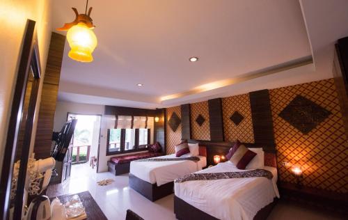 a hotel room with two beds and a television at Sita Beach Resort in Ko Lipe
