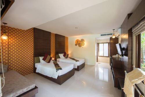 a hotel room with two beds and a television at Sita Beach Resort in Ko Lipe