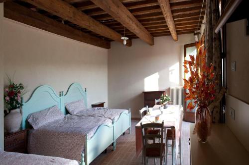 a bedroom with two beds and a table and a table sidx sidx sidx at Casale Talevi in Cartoceto