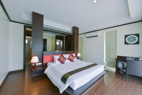 a bedroom with a large bed with red pillows at Sita Beach Resort in Ko Lipe