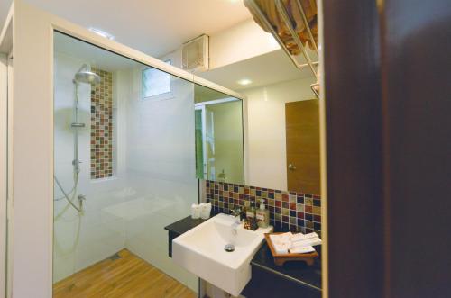 a bathroom with a sink and a shower and a mirror at Sita Beach Resort in Ko Lipe