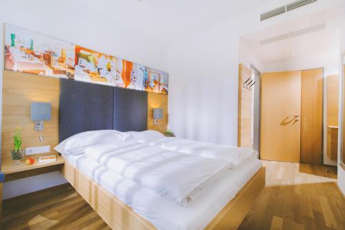 a large white bed in a room with at Gasthof Zur Traube in Neckenmarkt