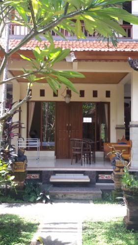 a house with a porch with a table and chairs at Bagus Homestay in Ubud