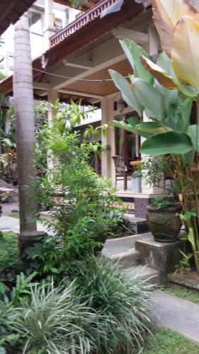 a garden with a flower and plants in front of a house at Bagus Homestay in Ubud