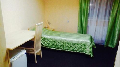 ナリヤン・マルにあるMini hotel 67 parallelのベッドルーム1室(デスク、緑のカバー付きベッド1台付)