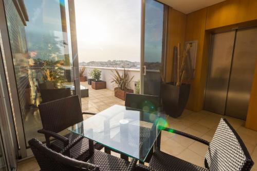 a dining room with a glass table and chairs at Eurosol Residence Hotel Apartamento in Leiria