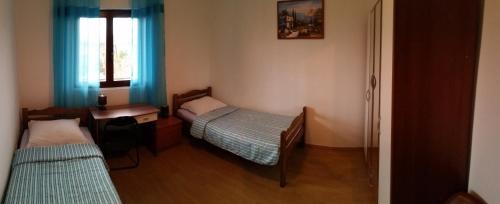 a small room with two beds and a window at Ivanka Apartment in Kaštela