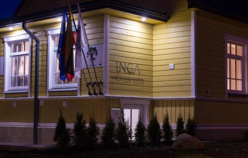 a house with flags on the side of it at night at Inga Vacation House in Druskininkai