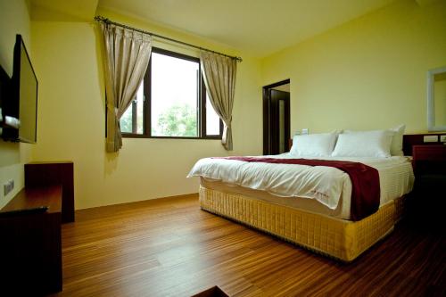 a bedroom with a large bed and a window at Sin Ging Hong Resort in Lugu