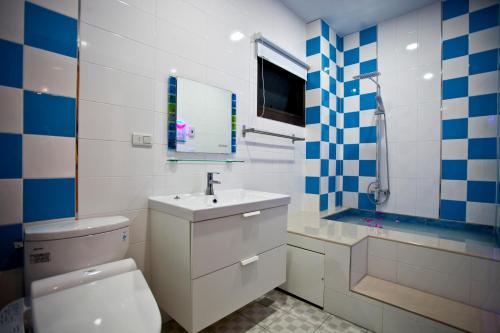 a bathroom with a white toilet and a sink at Sin Ging Hong Resort in Lugu