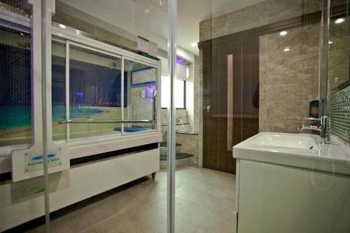 a bathroom with a sink and a glass shower at Sin Ging Hong Resort in Lugu