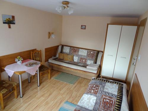 mały pokój z łóżkiem i stołem w obiekcie Willa Kalina w Solcu-Zdroju