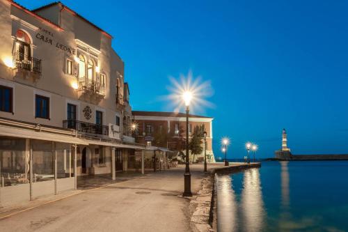 a street with a light and a lighthouse in the background at Casa Leone Hotel in Chania Town