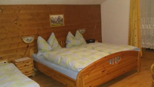 a bedroom with a large bed with a wooden wall at Ferienwohnung Waldhäusl in Sankt Martin bei Lofer