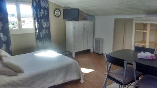 a bedroom with a bed and a table and a desk at Chambres d'Hôtes de la Grone in Argelès-sur-Mer
