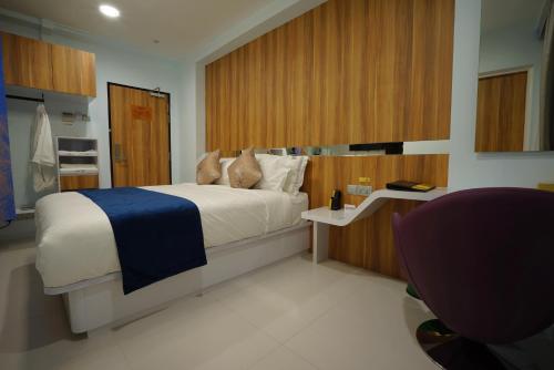 a bedroom with a bed with a blue blanket on it at five6 Hotel Splendour in Singapore