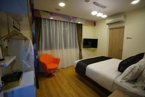 a hotel room with a bed and a chair at five6 Hotel Splendour in Singapore