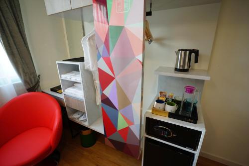 a small refrigerator with a red chair in a room at five6 Hotel Splendour in Singapore