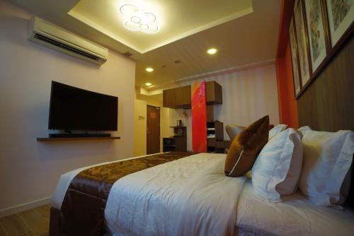 a hotel room with a bed with pillows and a television at five6 Hotel Splendour in Singapore