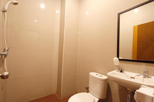 Palapa Hotel في ماتارام: حمام مع مرحاض ومغسلة ومرآة