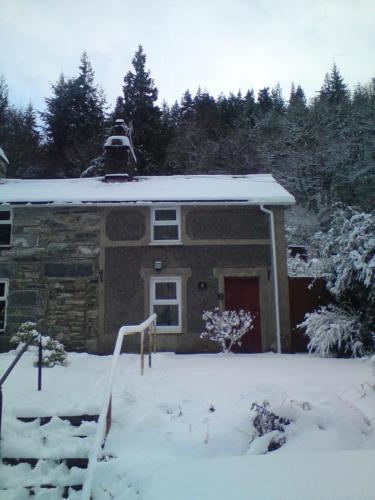 a house with snow on the roof of it at Llugwy Cottage in Betws-y-coed