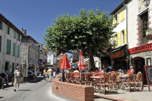 a group of tables and chairs with umbrellas on a city street at Chambres d'Hôtes de la Grone in Argelès-sur-Mer