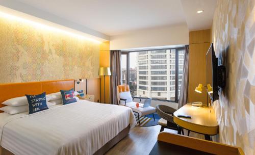 a hotel room with a bed and a large window at JEN Penang Georgetown by Shangri-La in George Town
