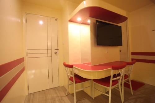 a small room with a table and a tv at Hotel 99 Monumento in Manila