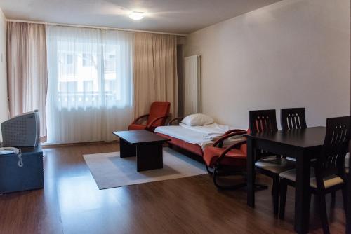 a room with a bed and a desk and a table at Bansko Royal Towers Hotel in Bansko