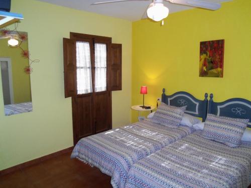 a bedroom with a bed and a window and a mirror at La Posada del Recovero in Genalguacil