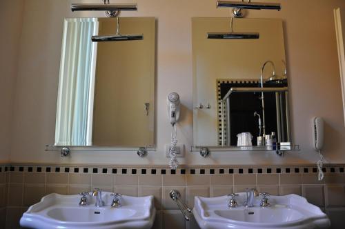 a bathroom with two sinks and a mirror at Hotel Patria in Pistoia